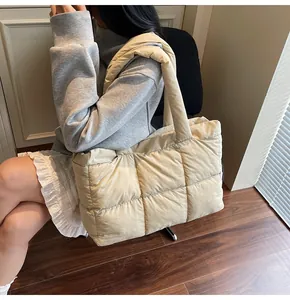 Detail of a beige quilted puffer tote bag showing soft texture and padded shoulder strap