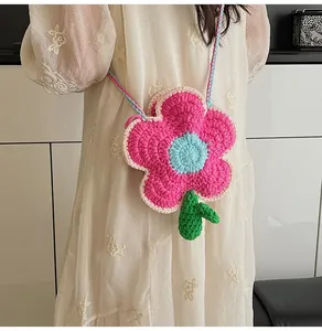 Detail of handmade crochet floral crossbody bag on model with blue and pink strap