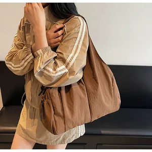 Detail of dark brown pleated nylon tote bag showing soft texture and large capacity