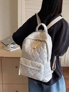 White quilted puffer backpack with diamond stitching shown worn by a model in lifestyle setting
