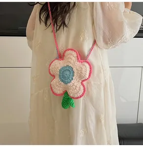 Detailed close-up of handmade crochet flower crossbody bag with soft wool texture