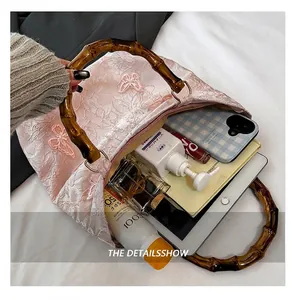 Spacious interior of a lace tote bag with bamboo handles showing large storage capacity