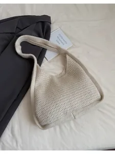 Close-up of the chunky knit texture and woven grid pattern on a cream shoulder bag