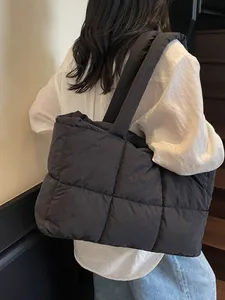 Minimalist black quilted puffer tote bag with wide straps shown on model for daily commute