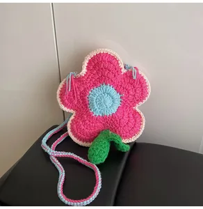 Close-up of handmade crochet flower shoulder bag featuring pink and blue knitted petals