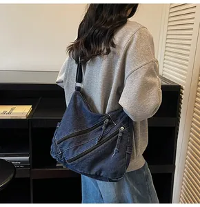 Detail view of large capacity denim tote bag with multiple diagonal zippers and black strap