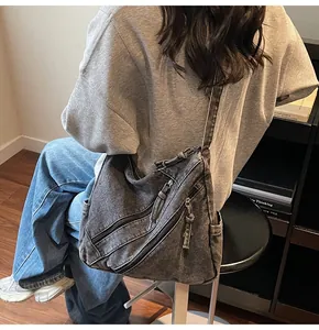 Detail view of charcoal denim tote bag with multi-zipper pockets on the shoulder