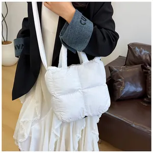 Detail view of a white quilted puffer bag featuring soft texture and crossbody strap
