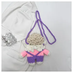Nahaufnahme einer handgehäkelten Lamm-Puppen Umhängetasche mit rosa und lila Strickstrukturen