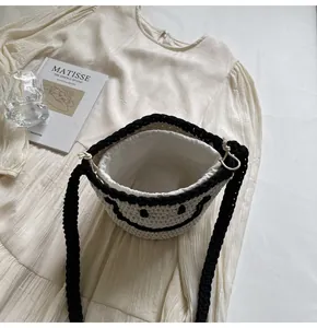 Detail of hand-woven smiley bucket bag with drawstring liner and black contrast handles