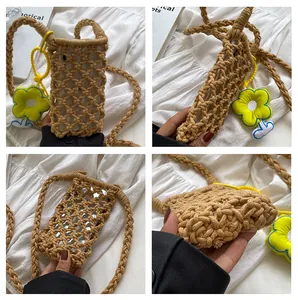 Detail view of a handmade woven phone bag with hollow mesh pattern and floral charm
