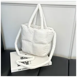 Close-up of white quilted puffer tote bag featuring soft padded texture and large grid pattern