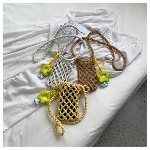 Detailed close-up of woven straw mini crossbody bags with colorful sunflower charms
