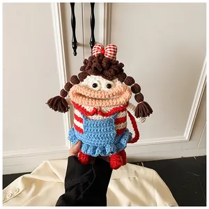 Detail of handmade crochet doll bag featuring red bow and blue overall dress details