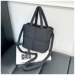 Detail of black quilted puffer tote bag showing soft padding and versatile shoulder strap