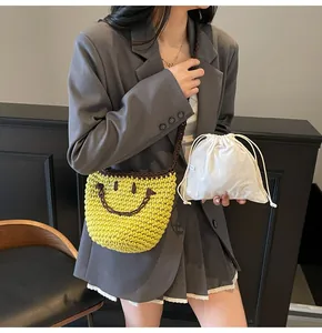 Detail of yellow crochet smiley face shoulder bag with removable white drawstring inner pouch