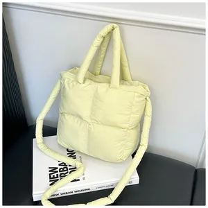 Detail view of light yellow quilted tote bag with soft padding and shoulder strap