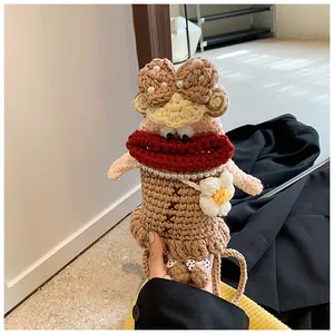 Détail du sac de téléphone au crochet fait main avec visage drôle et nœuds perlés