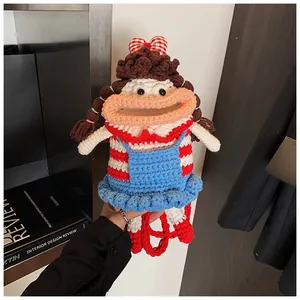 Close-up of handmade crochet doll bag showing red striped shirt and braided hair details
