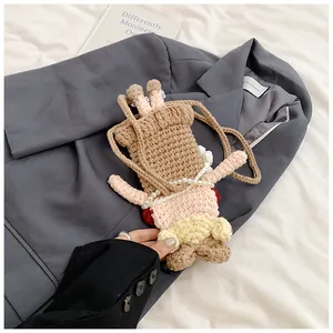 Détail du sac de poupée crocheté à la main avec chaîne de taille en perles sur tissu