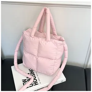 Macro view of a soft pink quilted puffy tote bag featuring a large square embossed pattern