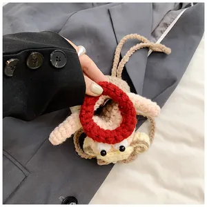 Détail d'un petit porte-monnaie poupée au crochet avec design de cheveux bouclés