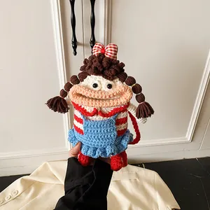 Detailed close-up of a handmade crochet doll crossbody bag with blue and red dress