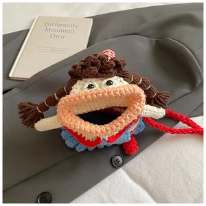 Close-up of handmade crochet girl doll bag with brown braids and red strap detail