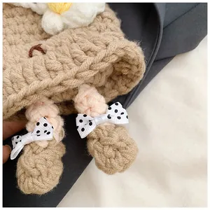 Détail d'un sac au crochet fait main avec texture tricotée et petite fleur