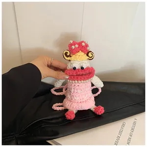 Detail of a handmade crochet doll bag featuring pink bow and funny cartoon facial features