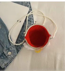 Dettaglio della borsa all'uncinetto rossa con tracolla di perle e chiusura metallica
