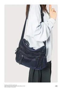 Detail view of multi-pocket vintage denim crossbody bag with adjustable shoulder strap
