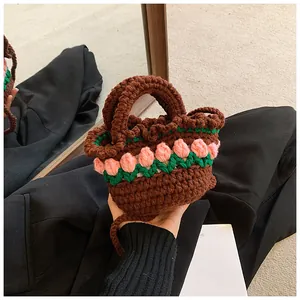 Dettaglio della mini borsa all'uncinetto con motivi di tulipani rosa e manico intrecciato