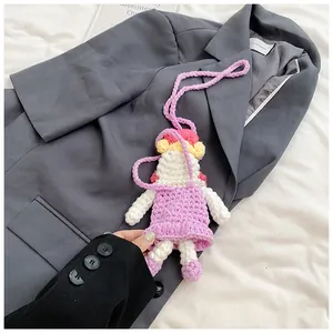 Close-up of handmade crochet doll bag with intricate knitting texture and purple dress