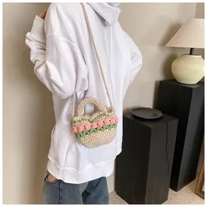 Dettaglio della mini borsa all'uncinetto con manico intrecciato e motivo a tulipano