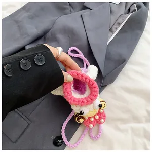 Detail of handmade crochet mini bag with pearl accents and cute button eyes design
