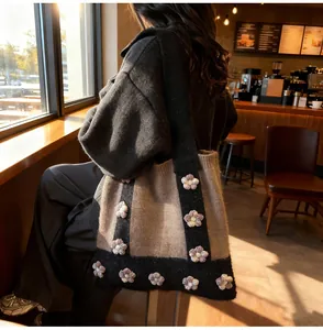 Détail d'un sac cabas en tricot avec fleurs et motif patchwork marron-noir en café