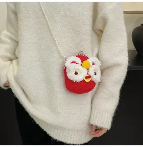 Dettaglio borsa rossa all'uncinetto con design danza del leone e tracolla di perle