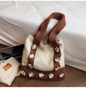 Détail d'un sac cabas en tricot blanc avec fleurs 3D faites main et larges poignées