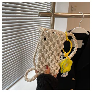 Detail of hand-woven cream mini crochet phone bag with yellow floral charm and inner lining