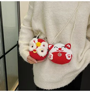 Dettaglio mini borsa in maglia fatta a mano con design leone e tracolla di perle