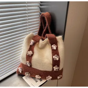 Détail d'un sac en tricot avec fleurs 3D et texture douce au fini pelucheux