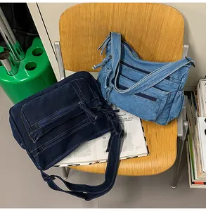 Detail of vintage denim crossbody bags in light and dark blue colors with zip pockets