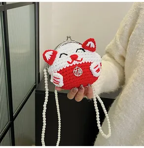 Dettaglio borsa gatto della fortuna all'uncinetto con ciondolo 福 e tracolla di perle