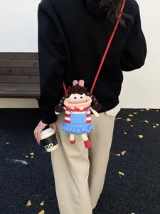 Cute crochet doll crossbody bag with pigtails shown on a model in an outdoor setting