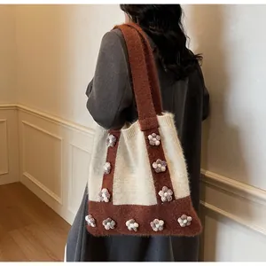 Vue détaillée du sac cabas en maille douce avec des fleurs au crochet en relief