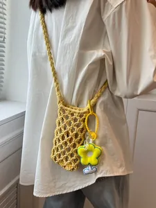 Handwoven yellow hollow mesh mini crossbody phone bag with a floral plush pendant