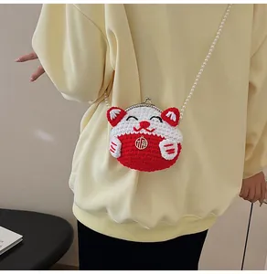 Dettaglio mini borsa gatto della fortuna all'uncinetto con catena di perle e ciondolo