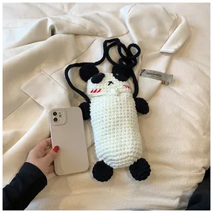 Detail of handmade crochet panda bag with knitted texture and long shoulder strap