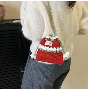 Detalle de bolso cubo de ganchillo rojo hecho a mano con flores y correa de punto